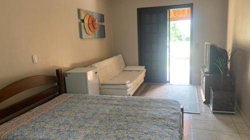 a bedroom with a bed and a couch in it at Aguas de São Pedro lugar Familiar e Aconchegante in São Pedro