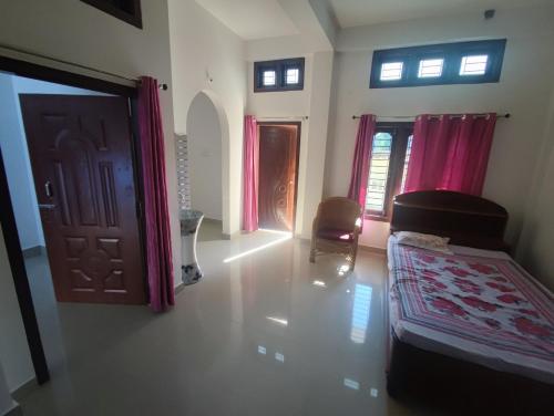 Zimmer mit Tür, Sofa und Stuhl in der Unterkunft Himanshu's place in North Lakhimpur