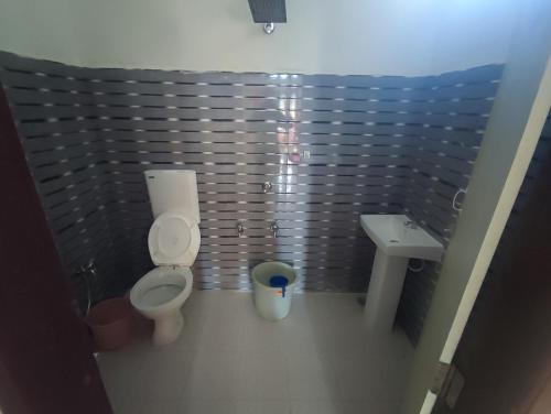 małą łazienkę z toaletą i umywalką w obiekcie Himanshu's place w North Lakhimpur