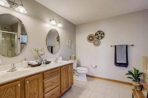 a bathroom with a sink and a toilet and a mirror at Lakefront Haven for Families Golfers and Girls Trips in Wisconsin Dells