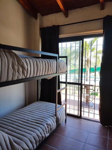 two bunk beds in a room with a balcony at Solares de Tanti in Tanti Nuevo
