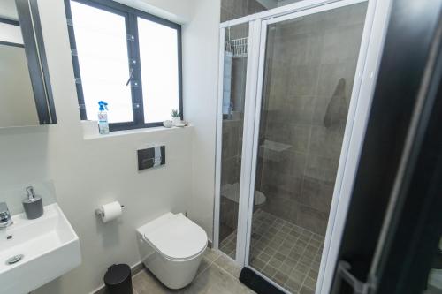 a bathroom with a shower and a toilet and a sink at Bella Cabana Luxury Apartment in Summerstrand