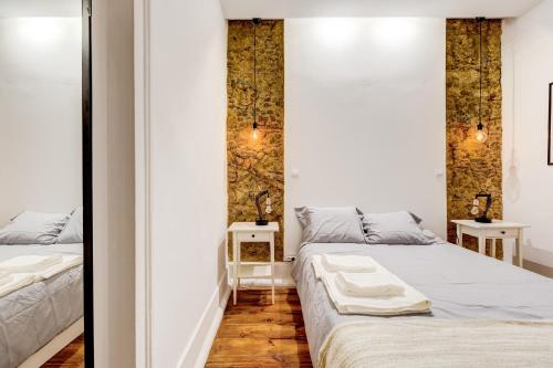 リスボンにあるHistorical Gem in Baixaの白い壁の客室内のベッド2台