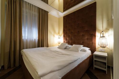 a bedroom with a large bed with two pillows at Nirvana SPA Center in Belgrade