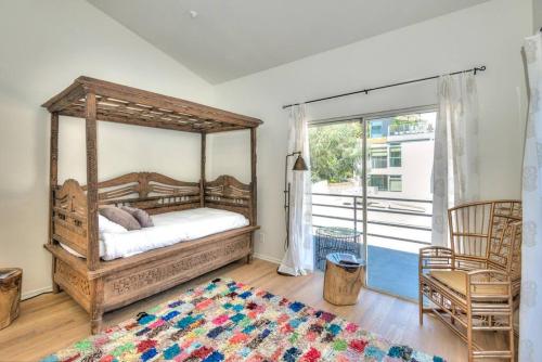 a bedroom with a wooden canopy bed and a window at Prime West Hollywood Designer Townhouse w Balcony in Los Angeles