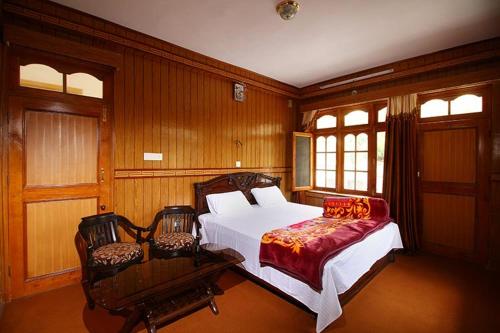 a bedroom with a white bed and two chairs at Hotel Lake view in Nako