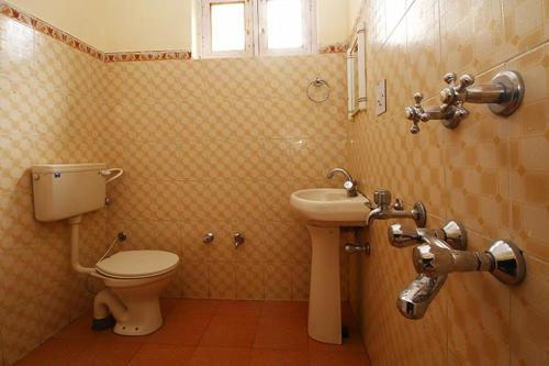 a bathroom with a toilet and a sink at Hotel Lake view in Nako