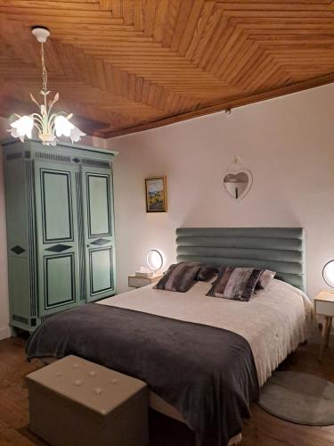- une chambre avec un lit et une armoire verte dans l'établissement Ancienne ferme restaurée, à Virazeil