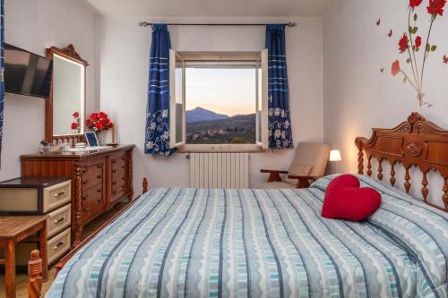 Un dormitorio con una cama con una almohada de corazón roja. en La Terrazza di Laurino, en Laurino