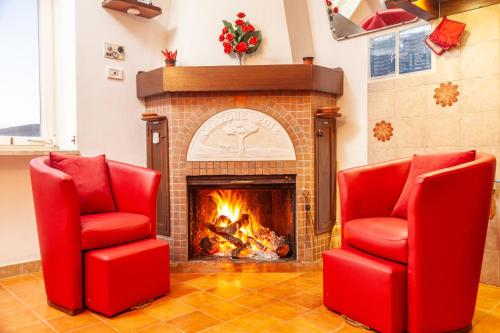 two red chairs in front of a fireplace at La Terrazza di Laurino in Laurino