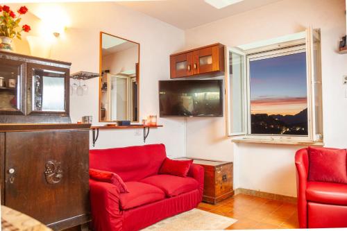 a living room with a red couch and a window at La Terrazza di Laurino in Laurino