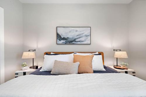 a bedroom with a white bed with two lamps at Coastal Hourglass in Port Bolivar