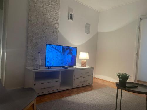 a living room with a flat screen tv on a dresser at Apartman Vuković in Novi Beograd