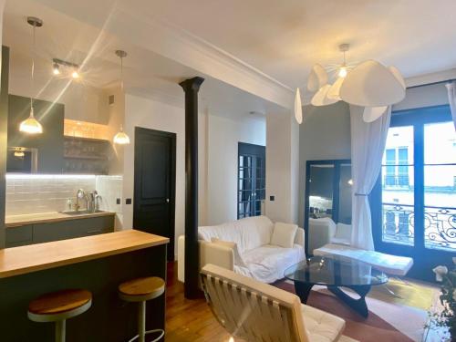 une cuisine et un salon avec un canapé et une table dans l'établissement Heart of marais calm and charming NEW, à Paris