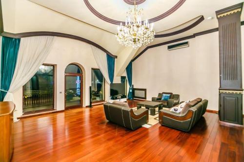 VIP Apartment PARMALAT في باكو: غرفة معيشة بها كنبتين وثريا