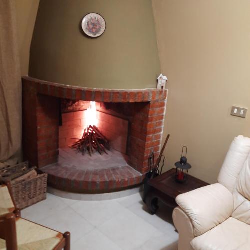 a living room with a brick fireplace with a clock on the wall at Casalustro in Citta' Sant'Angelo