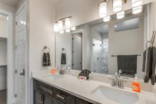 ein Badezimmer mit zwei Waschbecken und einem großen Spiegel in der Unterkunft Paseos 1121 Sleeps 15, Private Hot Tub, Near Sand Hollow, and Quail Lake in Washington