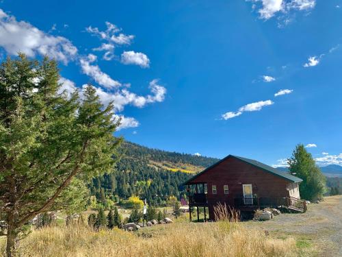 a small house in a field with sheep in front at Mammoth Overlook Of Yellowstone in Gardiner