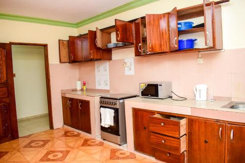 蒙巴薩的住宿－CRESCENT HOMES001，厨房配有木制橱柜和炉灶。