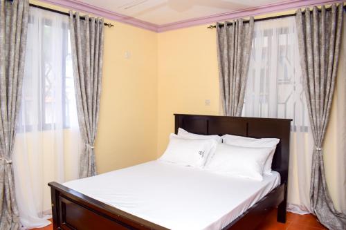 蒙巴薩的住宿－CRESCENT HOMES001，窗户客房内的一张带白色枕头的床
