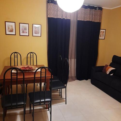 a dining room with a table and chairs and a couch at Casalustro in Citta' Sant'Angelo