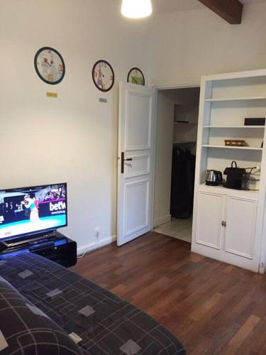 une chambre avec un lit et une télévision à écran plat dans l'établissement Appartement cosy près du Panthéon, à Paris