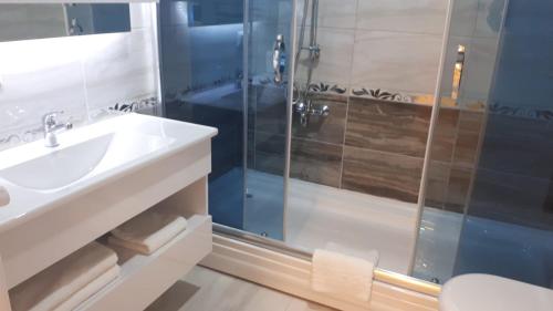 ein Bad mit einem Waschbecken und einer Dusche in der Unterkunft Mavili Suites in Bostancı