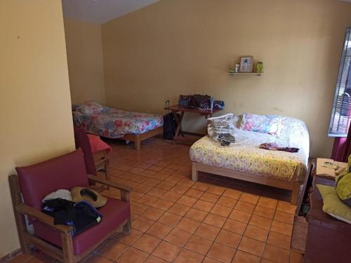 a room with three beds and a table and chairs at La Casita de Cieneguilla in Cieneguilla