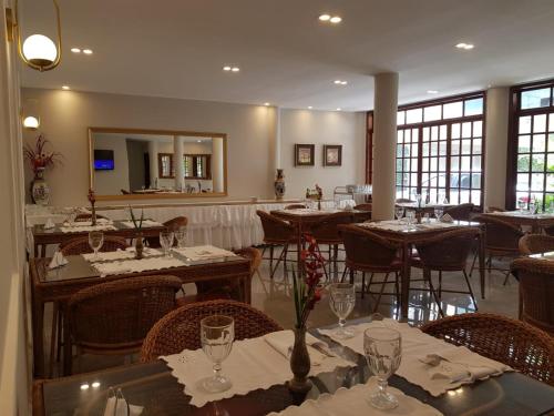 a restaurant with tables and chairs and a mirror at Caetité Palace Hotel in Caetité