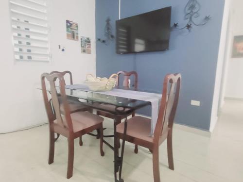 a dining room table with two chairs and a tv at Nueva Villa Apartment in Vega Baja
