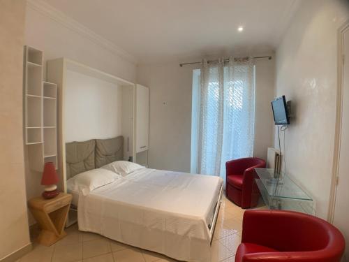 カンヌにあるAppartement Croisetteのベッドルーム1室(ベッド1台、赤い椅子付)