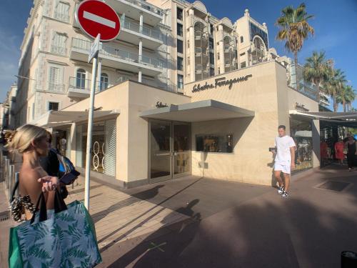 een man en een vrouw met boodschappentassen voor een gebouw bij Appartement Croisette in Cannes
