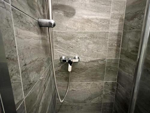 a shower with a hose in a shower stall at 4 bed house 10 min walk to Tube in London