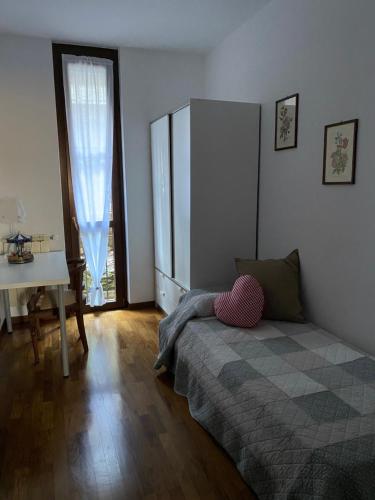 una camera da letto con un letto, una scrivania e una finestra di LA CASA NEL BOSCO, DI MARI ad Appiano Gentile