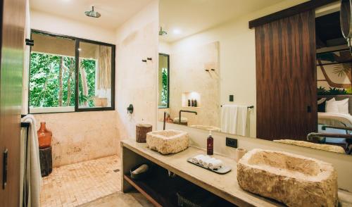 a bathroom with two sinks and a large mirror at Orchid House Tulum Jungle in Tulum