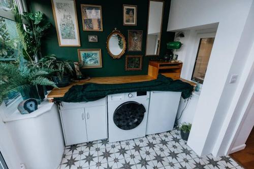 a washing machine in a room with a green wall at Unique Cottage in the heart of Ulverston in Ulverston