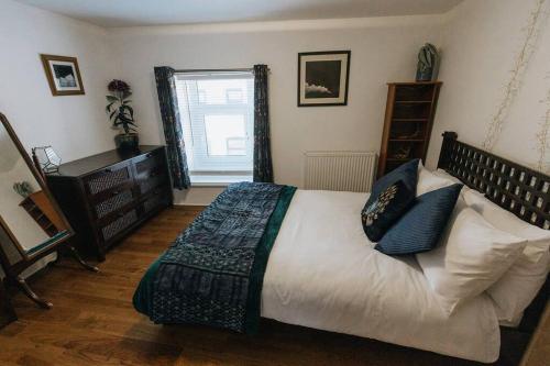 a bedroom with a large bed and a window at Unique Cottage in the heart of Ulverston in Ulverston