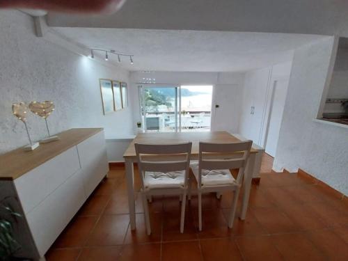 a kitchen and dining room with a table and chairs at Cala Salions Balandro II Tossa de mar in Cañet de Mar