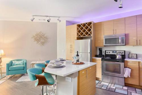 a kitchen with wooden cabinets and a white counter top at DT Charm Apt with Pool,Gym,Wine,WKSpace, Free Parking in Charlotte