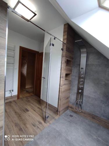 a bathroom with a glass shower in a room at Dworek. Lubkowo in Lubkowo