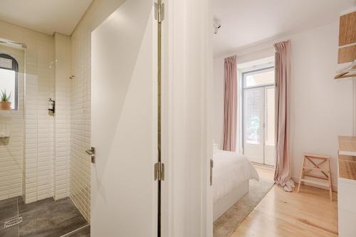 um quarto branco com uma cama e um chuveiro em Romantic Gem in Alfama em Lisboa