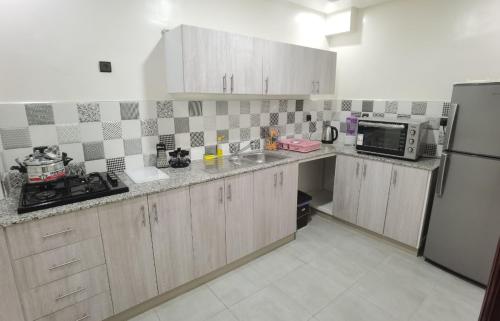 a kitchen with a sink and a microwave at شقق مفروسة المشور in Laayoune