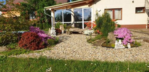 a garden with flowers in front of a house at Apartmán v centru Království sov in Králíky