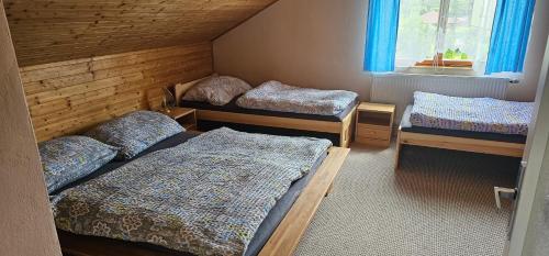 a room with three beds and a window at Apartmán v centru Království sov in Králíky