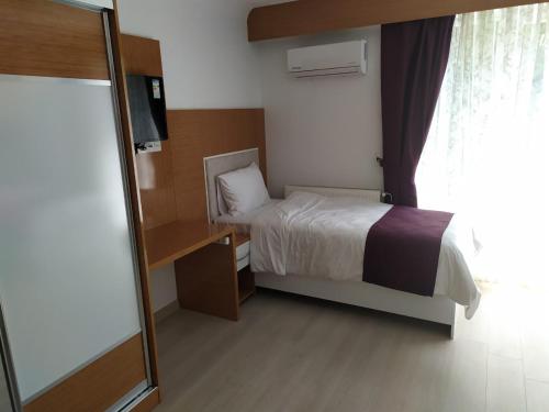 um pequeno quarto com uma cama e uma janela em KUYAŞ OTEL em Golbası