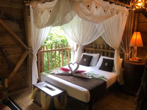 ein Schlafzimmer mit einem Himmelbett in der Unterkunft west indies cottage in Pointe-Noire