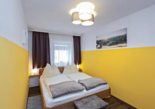 ツェル・アム・ゼーにあるAppartement Schlosserのベッドルーム1室(黄色い壁のベッド1台付)