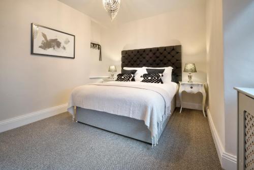 a bedroom with a large bed and two lamps at One Merewyke in Bowness-on-Windermere