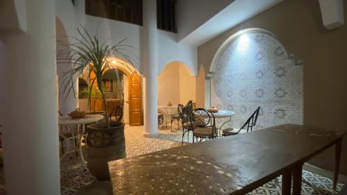 una habitación con mesa y sillas y una habitación con mesa y mesa en Riad D’AR GANne by Carole, en Essaouira