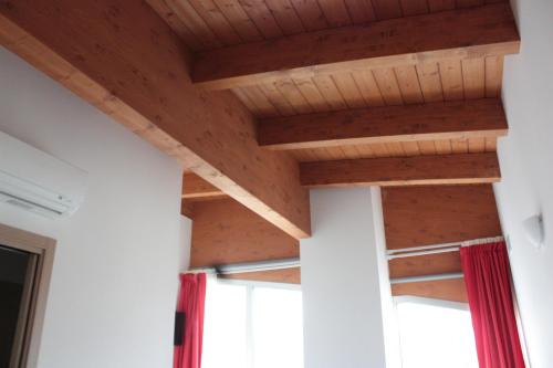 a room with wooden ceilings and windows at B&B delle Arti in Preturo